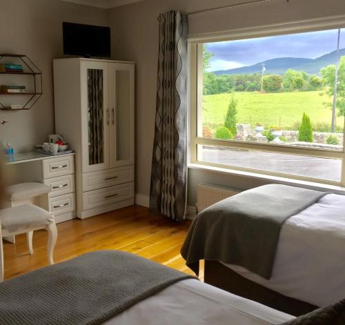 a bedroom with a bed and a window with a view at Laburnum B&B in Kenmare