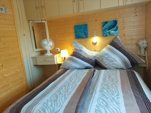 a bedroom with a bed with a wooden wall at Domus Mare domek holenderski in Wisełka
