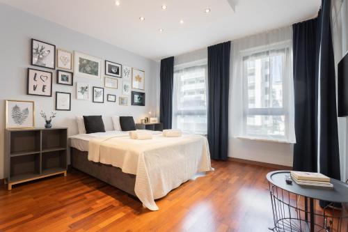 een slaapkamer met een bed met een tafel en een raam bij Golden Apartments Warsaw -New Stylish Apartments in the City Center- Rondo Daszynskiego- Gieldowa in Warschau