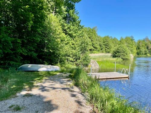 a small boat on a dock on a lake at Holiday Home Småland Paradiset in Ryd