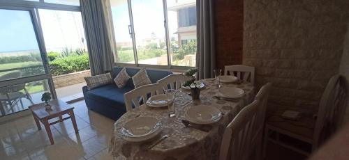Dawwār ‘Abd al Qādir Qāsim的住宿－شاليه مرقيا بالساحل الشمالي صف اول بحر，一间带桌子和蓝色沙发的用餐室