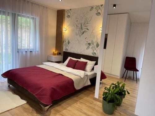 a bedroom with a large bed with a red blanket at Casa Fratila in Holbav