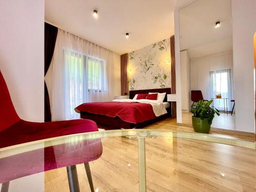 a bedroom with a red bed and a red chair at Casa Fratila in Holbav