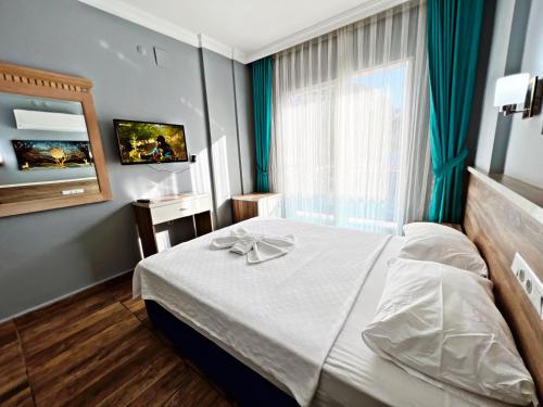 Habitación de hotel con cama y ventana en Opalin Otel, en Kemer
