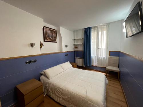 Habitación pequeña con cama y TV. en Pensión Irune by Vivere Stays, en San Sebastián