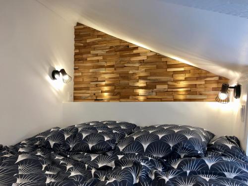 une chambre avec un lit noir et blanc avec un mur de briques dans l'établissement La cabane urbaine et son jardin, à Rouen