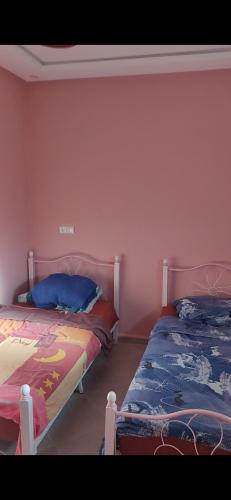 two beds sitting next to each other in a bedroom at Isila blanca in Sidi Bouzid