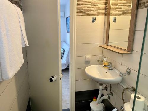 małą łazienkę z umywalką i lustrem. w obiekcie Beach 'Glyfada' apartment 118 w mieście Glifada