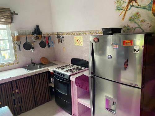 a kitchen with a stainless steel refrigerator and a stove at Greenpointholbox in Holbox Island