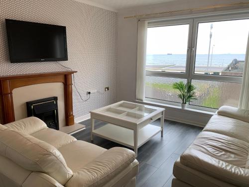 a living room with a couch and a fireplace at Buchanan court 2 bedroom flat in Fife