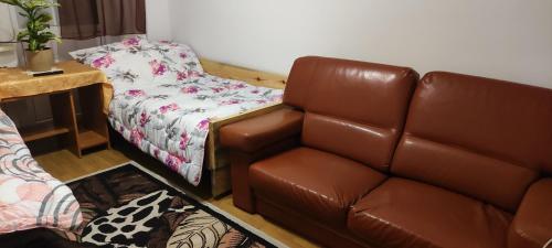 a living room with a brown leather couch and a desk at Wypoczynek na wsi in Tomaszów Lubelski