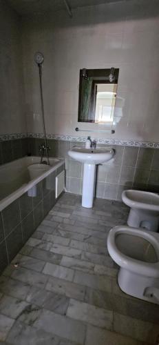 uma casa de banho com 2 WC, um lavatório e um espelho. em Residence L'ermitage One bedroom apartment em Mohammedia