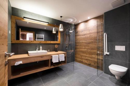 y baño con aseo, lavabo y ducha. en Sepp & Hannis Suiten im Dorf en Neustift im Stubaital