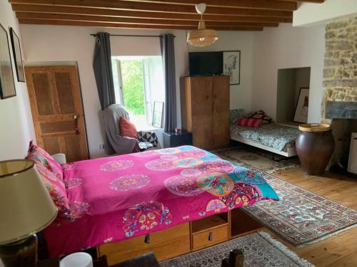 a living room with a pink bed in a room at Découverte d'un Haras proche du Mont St Michel in Hambye