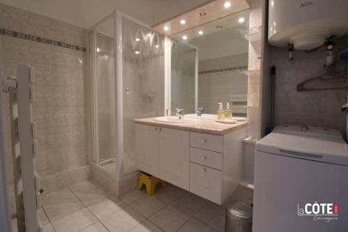 uma casa de banho branca com um lavatório e um espelho em La Galiote - 4 couchages em Carry-le-Rouet