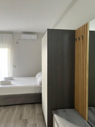 a small bedroom with a bed and a window at Lotus Apartments in Vlorë