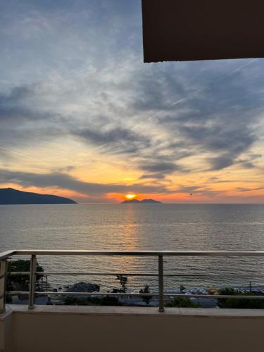 a view from a balcony of a sunset over the ocean at Lotus Apartments in Vlorë