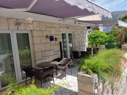 a patio with chairs and tables and an umbrella at Apartment AB Batala in Dubrovnik