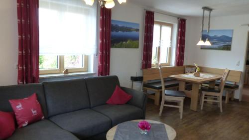 ein Wohnzimmer mit einem Sofa und einem Tisch in der Unterkunft Allgäuer Landhaus Stocker in Hopferau
