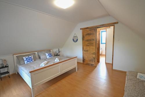 a large bedroom with a bed and a wooden floor at Villa Popeye Jakuzzis nyaralóház in Békésszentandrás