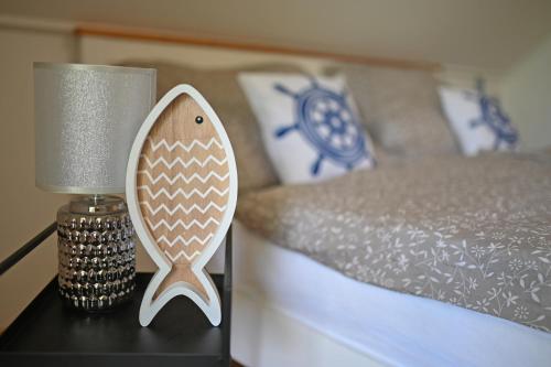 a table with a lamp and a rocket figurine on a bed at Villa Popeye Jakuzzis nyaralóház in Békésszentandrás