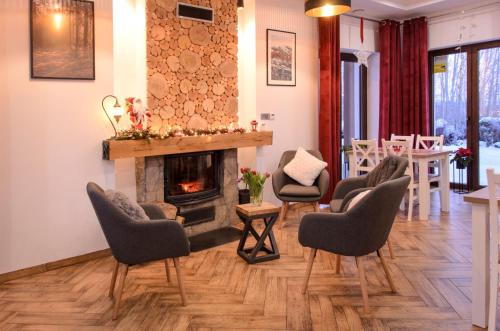 a living room with chairs and a fireplace at Karkonoskie Widoki in Karpacz