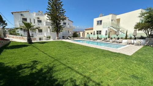 a large yard with a swimming pool in front of a house at Cost Mari Almyrida New by ZAGO Boutiqe hotels in Almirida