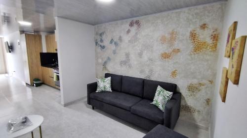 ein Wohnzimmer mit einem Sofa und einer Wand in der Unterkunft Edificio GrandSky in Cali