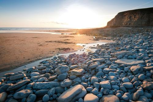 a large group of rocks on a beach at Pavilion in Llantwit Major