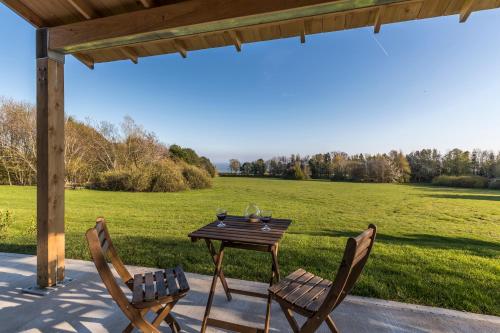 a table and two chairs on a patio with a field at Pavilion in Llantwit Major