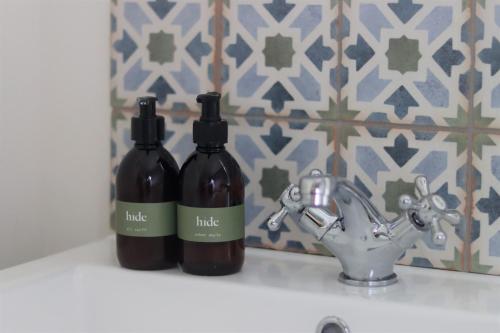 two bottles of wine sitting next to a bathroom sink at Pavilion in Llantwit Major