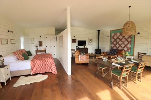 a bedroom and living room with a bed and a table at Pavilion in Llantwit Major