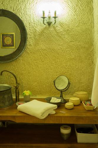 a bathroom counter with a mirror and a sink at Hezen Cave Hotel in Ortahisar