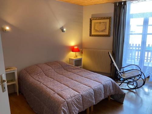 1 dormitorio con 1 cama, 1 silla y 1 ventana en Le petit Luxembourg, en Valleraugue