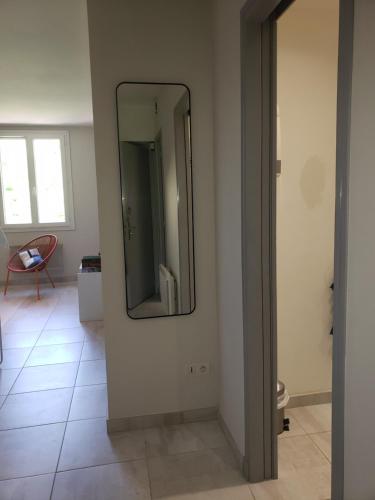 une salle de bain avec un miroir au mur dans l'établissement le central 300 metres de la plage, à Cassis