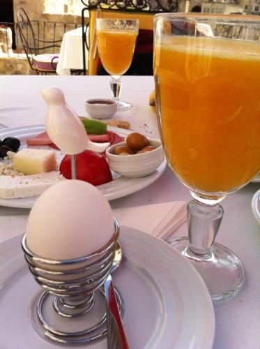 a table with a plate of food and a drink at Hezen Cave Hotel in Ortahisar