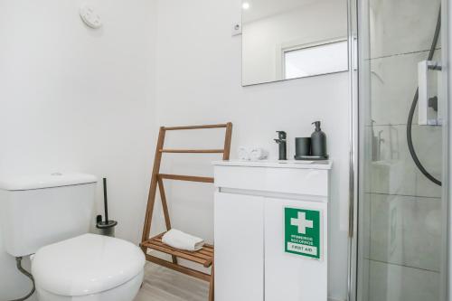 a white bathroom with a toilet and a shower at Hygge Chiado in Lisbon