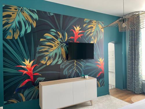 a bedroom with a wall mural of tropical plants at Aux Remparts de Montreuil in Montreuil-sur-Mer