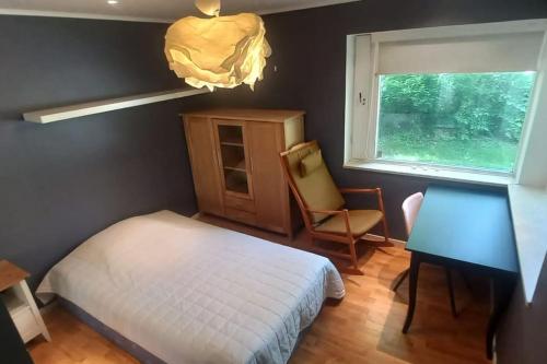 a bedroom with a bed and a chair and a window at A wonderful house in the lake. in Stockholm