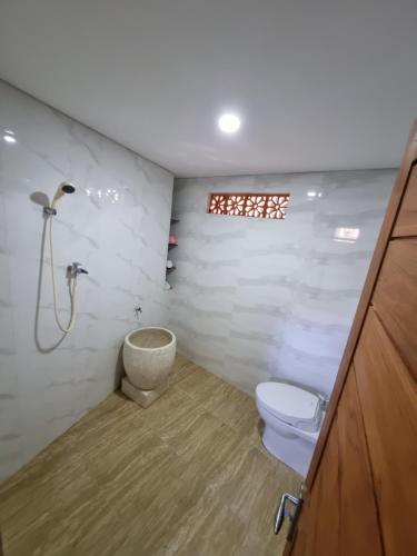 een badkamer met een toilet en een douche bij Joglo Catu Villa in Singaraja