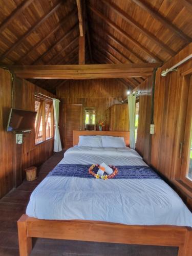 een groot bed in een kamer met een houten plafond bij Joglo Catu Villa in Singaraja
