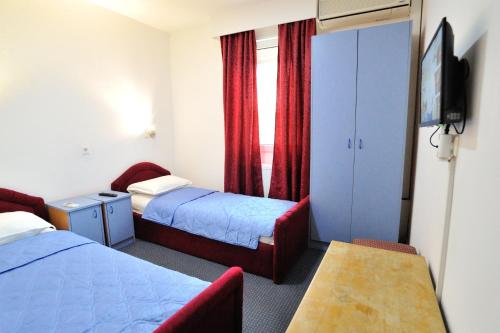 内乌姆Hotel Lav的一间有两张床和一台电视的酒店房间