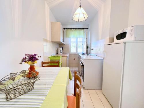 eine Küche mit einem Tisch und einem weißen Kühlschrank in der Unterkunft Mary Loo Apartments Rab in Rab