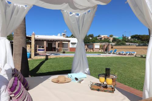 uma mesa com um chapéu e dois copos de sumo de laranja em Villa los Tablazos SpainSunRentals 1009 em Frigiliana