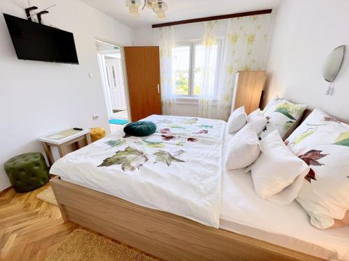una camera da letto con un grande letto con foglie sopra di Mary Loo Apartments Rab a Rab