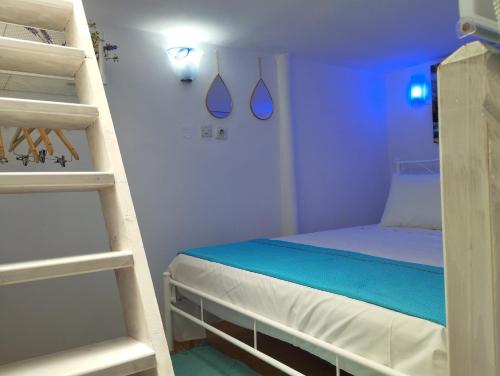 mały pokój z łóżkiem i drabiną w obiekcie Mari...Milo w mieście Péran Triovasálos