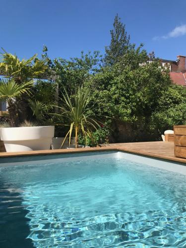 une piscine avec de l'eau bleue dans une cour dans l'établissement Aux Remparts de Montreuil, à Montreuil-sur-Mer