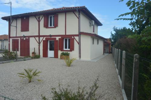 une maison avec une clôture devant dans l'établissement Maison landaise rénovée avec charme, à Lit-et-Mixe