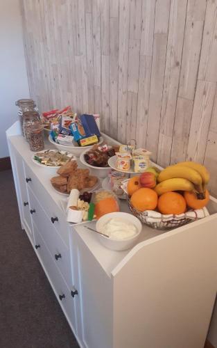 a buffet of food with bananas oranges and other foods at Sea Lodge B&B in Durrus