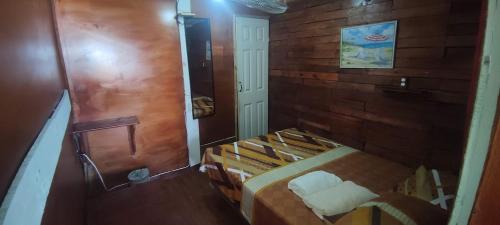 a small room with a bed and a mirror at Victoria s Beach House and Snorkeling Center in Roatan